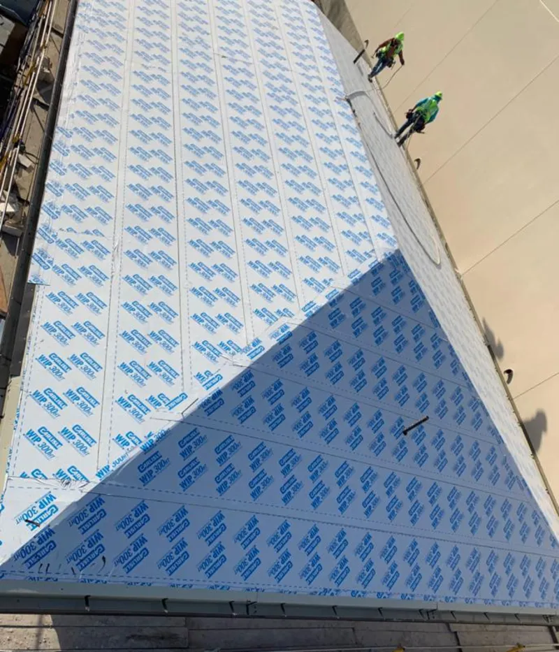 Professional roofers installing underlayment on a metal roof in Port Chester